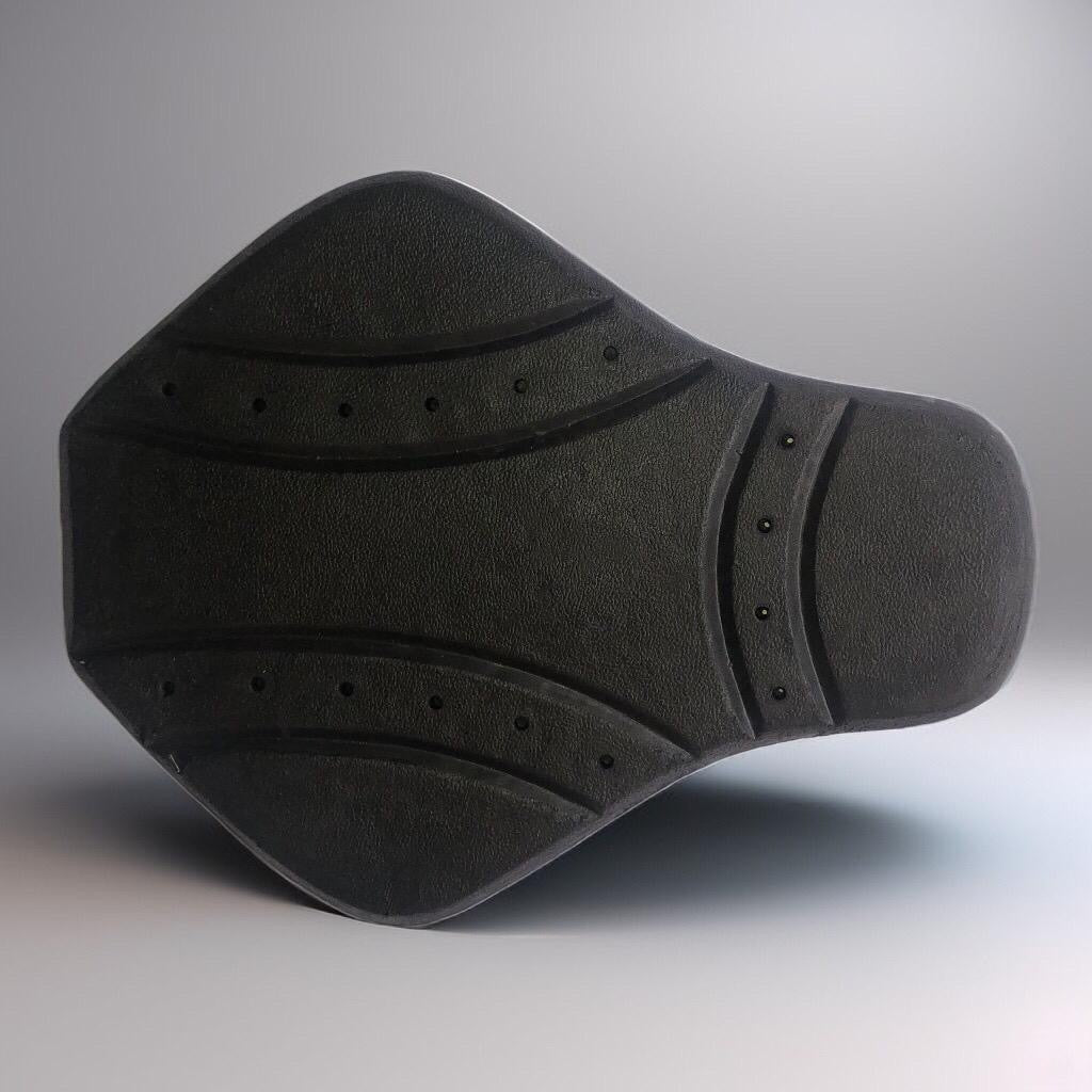 Angled view of the black Motovational CE Level 1 back protector with ventilation holes on a grey background